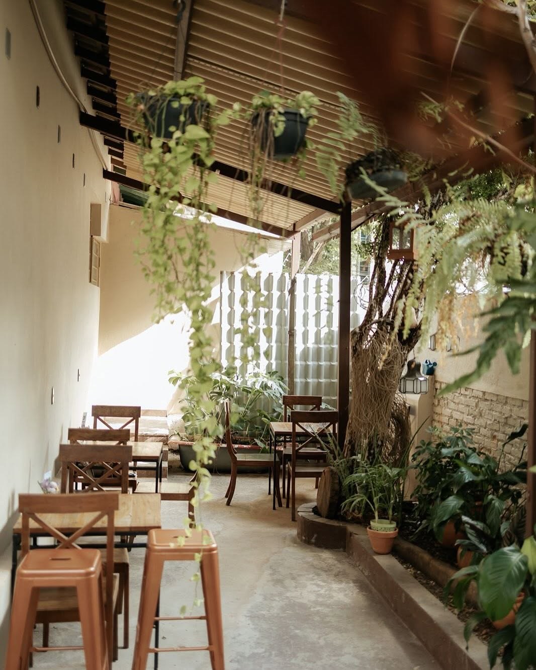 The plant filled outdoor courtyard seating area at Café das Amoras